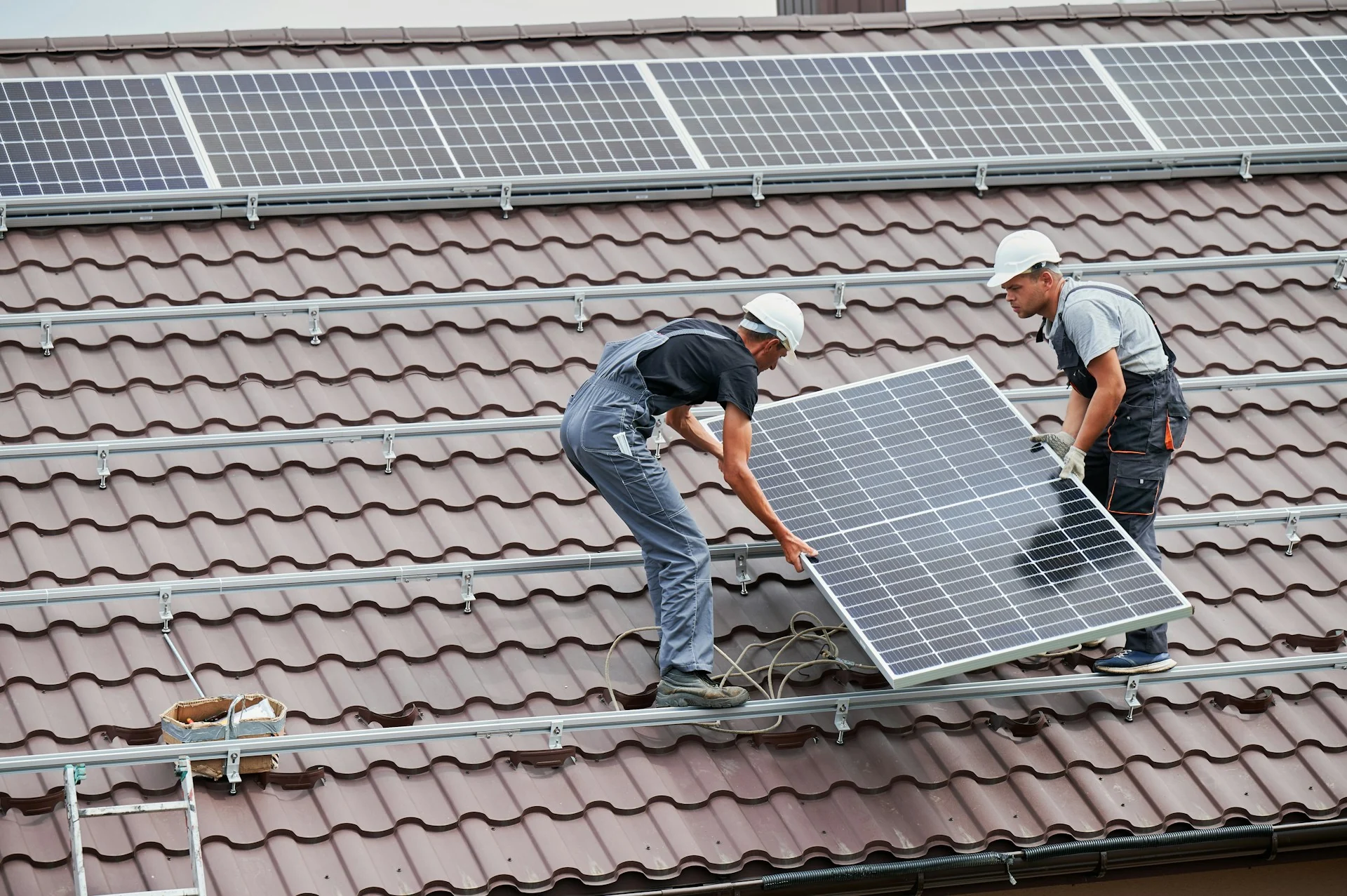 Solar professionals installing panels on a roof
